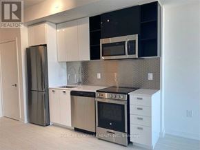 Toronto (York University Heights) condo for rent - A kitchen with black and white appliances and cabinets.