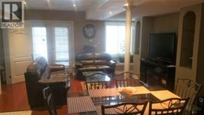 Ancaster apartment for rent - A living room with a couch, chairs, and a television.