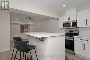 St. Marys condo for rent - A kitchen with a white counter top and black chairs.