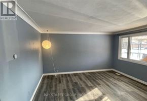 Niagara Falls (Arad/Fallsview) apartment for rent - A room with a wooden floor and a hanging light fixture.