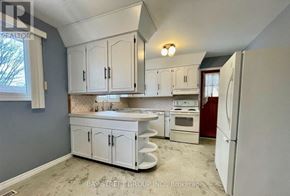Niagara Falls (Arad/Fallsview) apartment for rent - A kitchen with white cabinets and appliances, including a refrigerator, sink, and oven.
