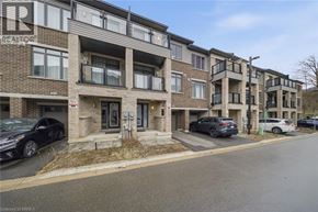 Brantford townhouse for rent - A street view of a residential area with apartment buildings and parked cars.