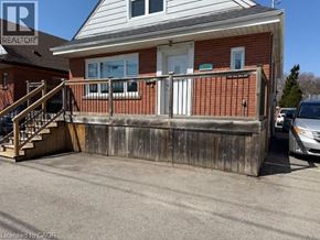 Hamilton apartment for rent - A house with a wooden fence and a car parked in front.