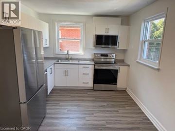 Hamilton apartment for rent - A kitchen with a refrigerator, sink, oven, and microwave.