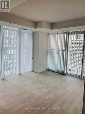 Toronto (Church-Yonge Corridor) condo for rent - A room with wooden flooring and white vertical blinds on the windows.