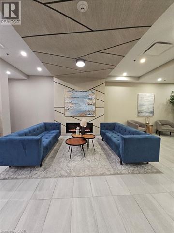 Kitchener condo for rent - A living room with a blue couch and a coffee table.
