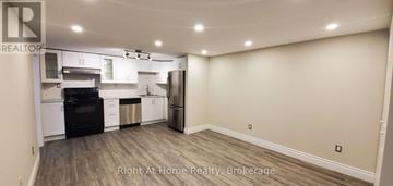 Oakville (Wo West) apartment for rent - A kitchen with a black fridge and stove top oven.