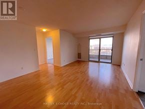 Mississauga (City Centre) condo for rent - A room with wooden flooring and a sliding glass door leading to a balcony.