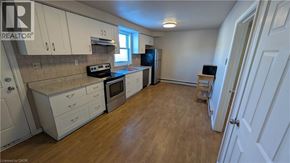 Stoney Creek apartment for rent - A kitchen with white cabinets and wooden floors.