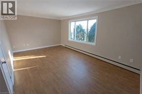 Stoney Creek apartment for rent - A room with wooden flooring and a large window.