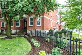 London East (East F) condo for rent - A red brick building with a black fence and a tree in front.