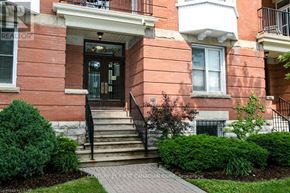 London East (East F) condo for rent - A red brick building with a black railing and a sign that says "Century 21 First Canadian Corp.".