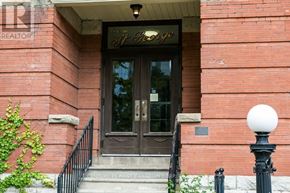 London East (East F) condo for rent - A red brick building with a black door and a sign that says "First Canadian Bank".