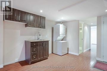 Vaughan (Patterson) apartment for rent - A kitchen area with wooden cabinets and a white refrigerator.