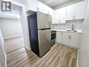 Wallaceburg apartment for rent - A kitchen with a stainless steel refrigerator and wooden floors.