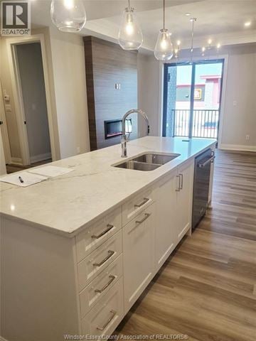 Lasalle condo for rent - A kitchen with white cabinets and a marble countertop.