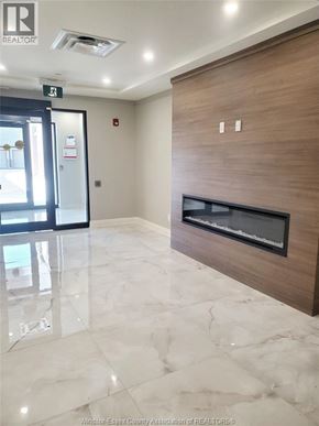 Lasalle condo for rent - A modern hallway with a marble floor and a wooden door.