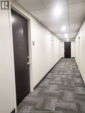 Lasalle condo for rent - A long hallway with carpeted floors and doors on either side.