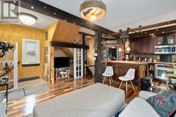London East (East F) multi-family for rent - A living room with a grey couch and a wooden ceiling.