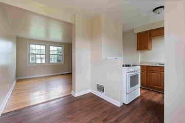 Syracuse apartment for rent - A kitchen with a white stove top oven and wooden cabinets.