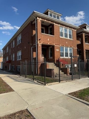 Chicago apartment for rent - A red brick apartment building with a black fence in front.