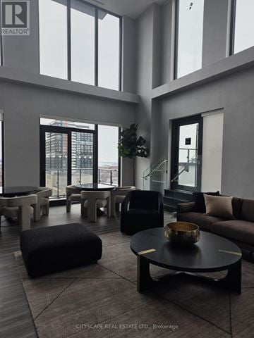 Hamilton (Corktown) condo for rent - A living room with a black coffee table and a large window.