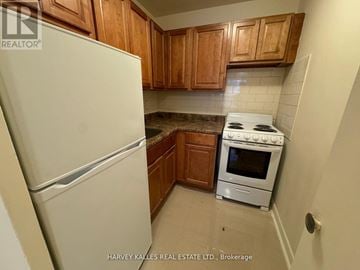 Toronto (East York) condo for rent - A kitchen with a white fridge and a white stove.