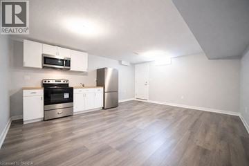 Brantford apartment for rent - A kitchen with a stove top oven, microwave, and refrigerator.