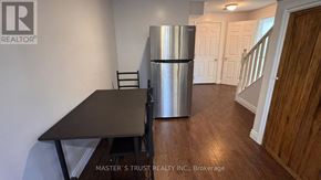 Guelph (Kortright East) apartment for rent - A kitchen with a table and chairs and a refrigerator.