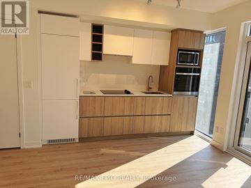 Toronto (Church-Yonge Corridor) condo for rent - A kitchen with wooden cabinets and a white fridge.