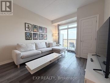 Milton (Wi Willmott) condo for rent - A living room with a white couch and a television.