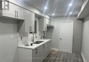Brampton (Brampton West) apartment for rent - A small, white kitchen with a sink and cabinets.