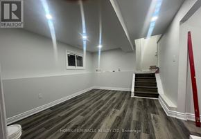 Brampton (Brampton West) apartment for rent - A room with wooden flooring and a staircase leading to another room.