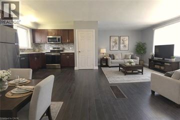 Hamilton apartment for rent - A well-lit, modern kitchen and living room with dark wood floors and furnished with a dining table and chairs.
