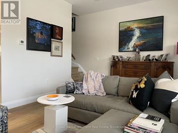 Guelph (Downtown) townhouse for rent - A living room with a grey couch and a painting on the wall.