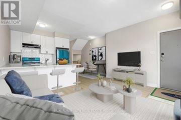 Ottawa condo for rent - A modern living room with a grey couch and a white kitchen area.