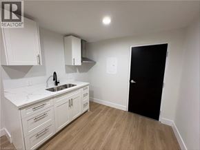 Port Colborne apartment for rent - A kitchen with white cabinets and a black door.