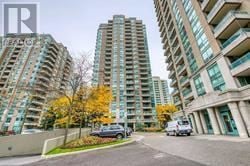 Toronto (Newtonbrook East) condo for rent - A street view of a residential area with cars parked on the side of the road and tall buildings in the background.