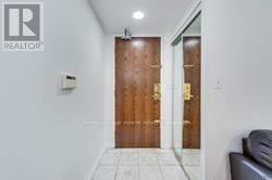 Toronto (Newtonbrook East) condo for rent - A hallway with a wooden door and a Realtor sign on the wall.