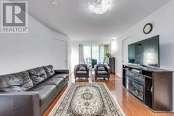 Toronto (Newtonbrook East) condo for rent - A living room with a grey couch and a rug in the middle.