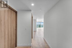 Toronto (Waterfront Communities) condo for rent - A hallway with a wooden door and a window in the distance.