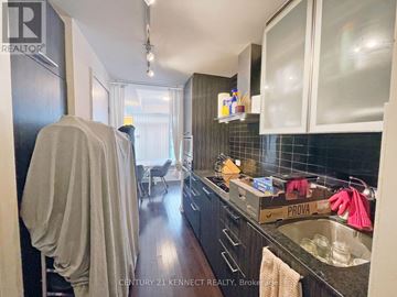 Toronto (Waterfront Communities) condo for rent - A kitchen with a black refrigerator and a white counter top.