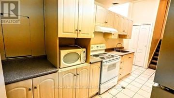 Vaughan (Vellore Village) apartment for rent - A kitchen with wooden cabinets and a microwave on top of the oven.