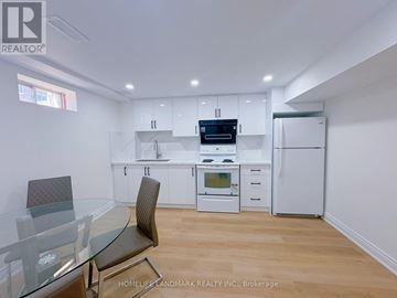 Markham (Greensborough) apartment for rent - A modern kitchen with white cabinets and a glass table.