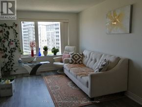 Markham (Commerce Valley) condo for rent - A living room with a couch, a table, and a window.