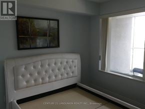 Markham (Commerce Valley) condo for rent - A white tufted headboard in a room with a painting on the wall.