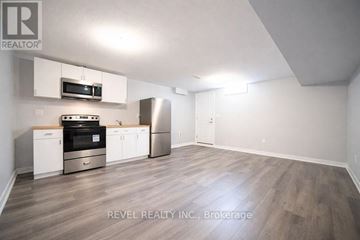 Brantford apartment for rent - A kitchen with white cabinets and a stainless steel refrigerator.
