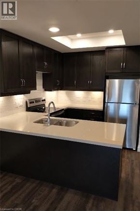 Waterdown condo for rent - A modern kitchen with dark wood cabinets and stainless steel appliances.