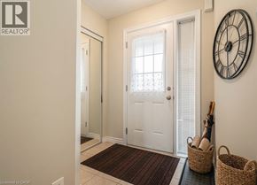 Kitchener townhouse for rent - A hallway with a white door and a clock on the wall.