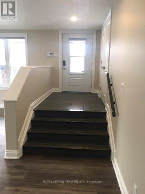 Ottawa multi-family for rent - A hallway with a staircase leading to a door.